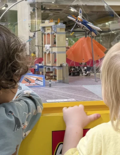 Kinder bestaunen Lego Spielanlage durch das Fenster